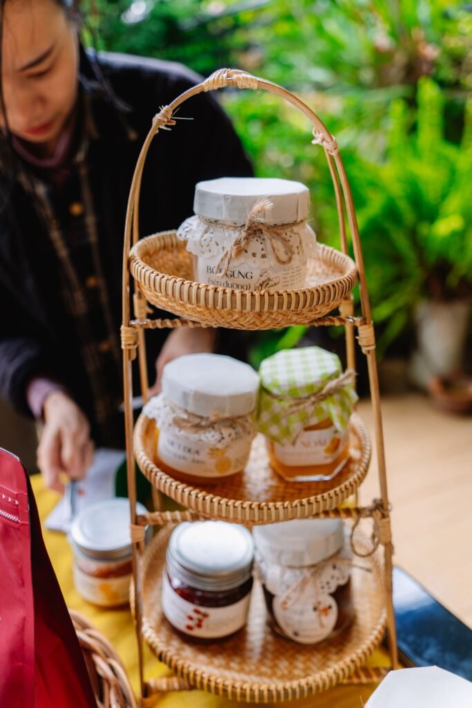 Handmade preserves displayed on a wicker stand at a local market.