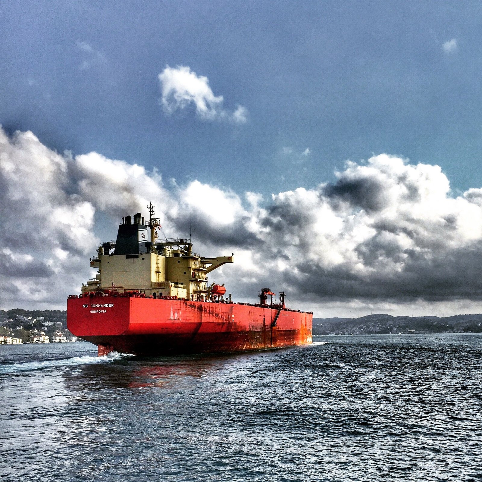 lawn-01 Red cargo ship navigating the Bosphorus under dramatic clouded sky, Turkey.